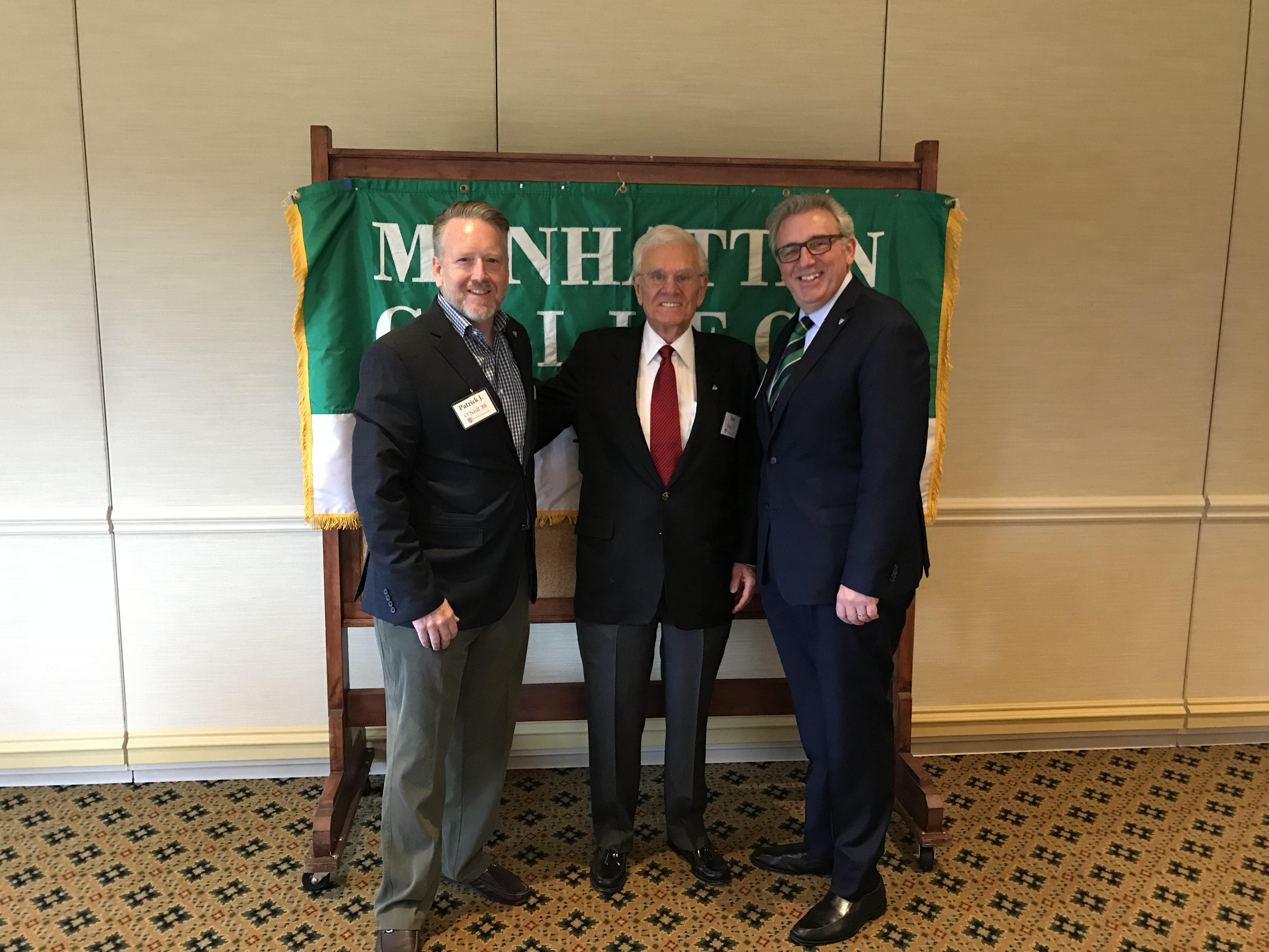 2018 Jaspers of Georgia hosts, Pat O'Neill '88 and Bob Fink '57, with Alumni Director, Louis Calvelli in front of Alumni banner